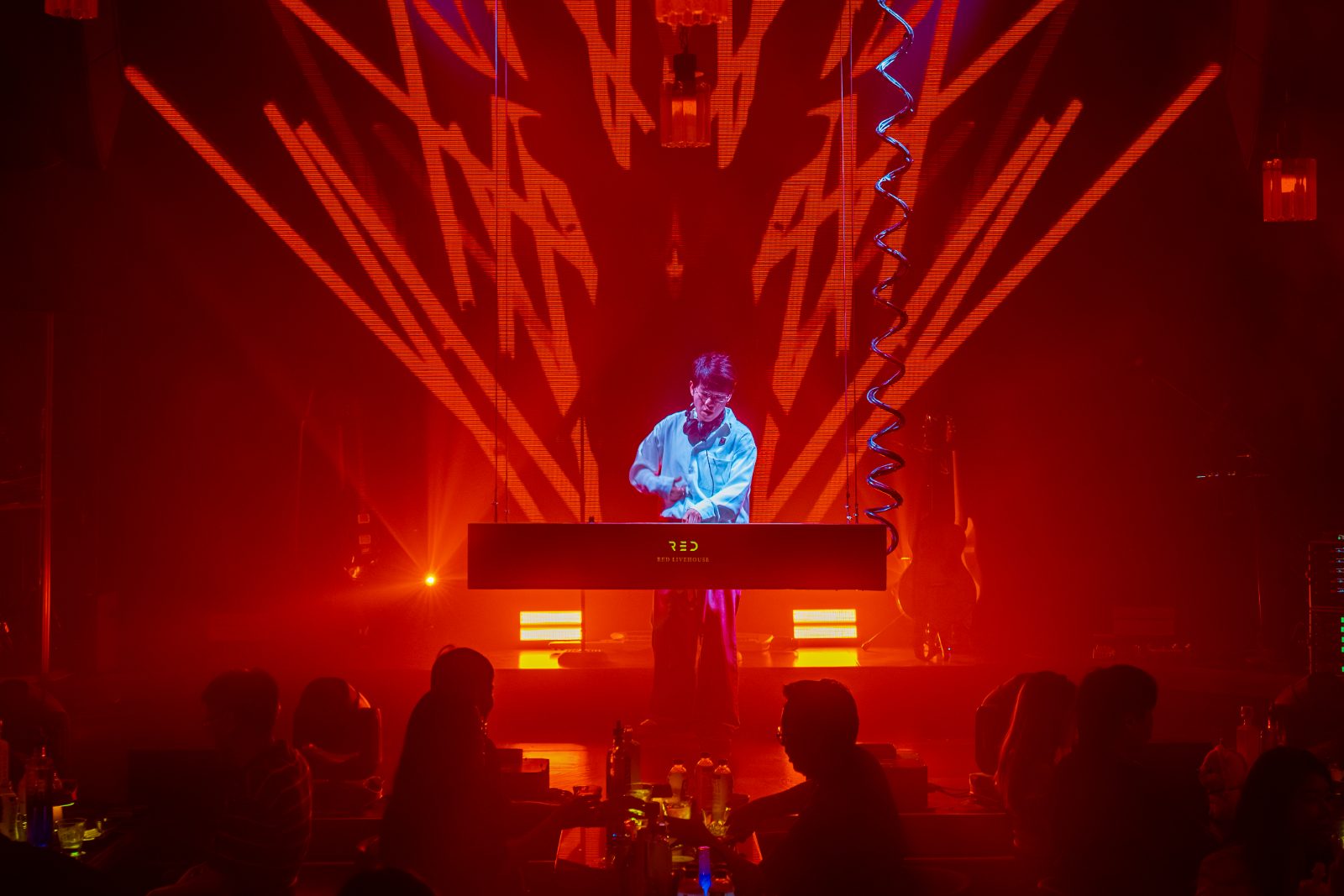 The DJ booth under red laser light