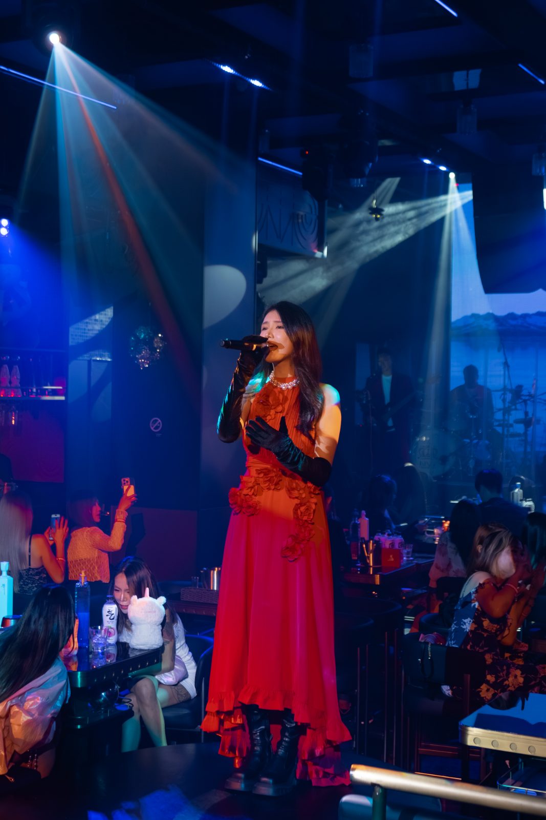 A singer in red performing on the RED Live House stage